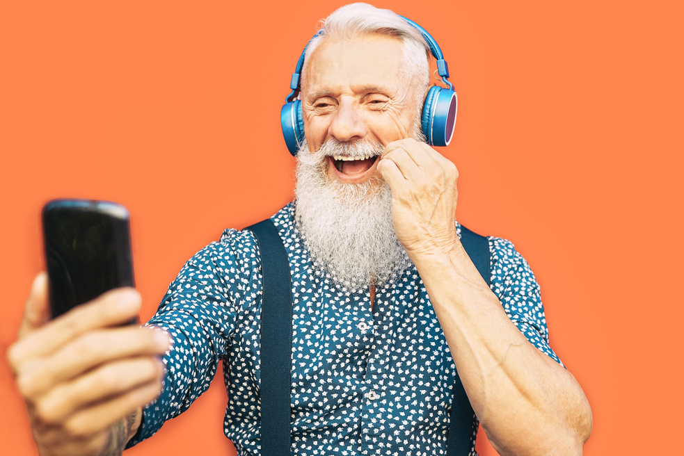 Smiling Senior Man with Headphones Taking Selfie with His Smartphone